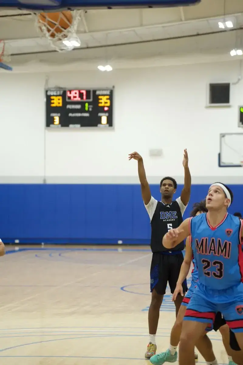 Basketball player celebrating as ball drops through net during competitive game