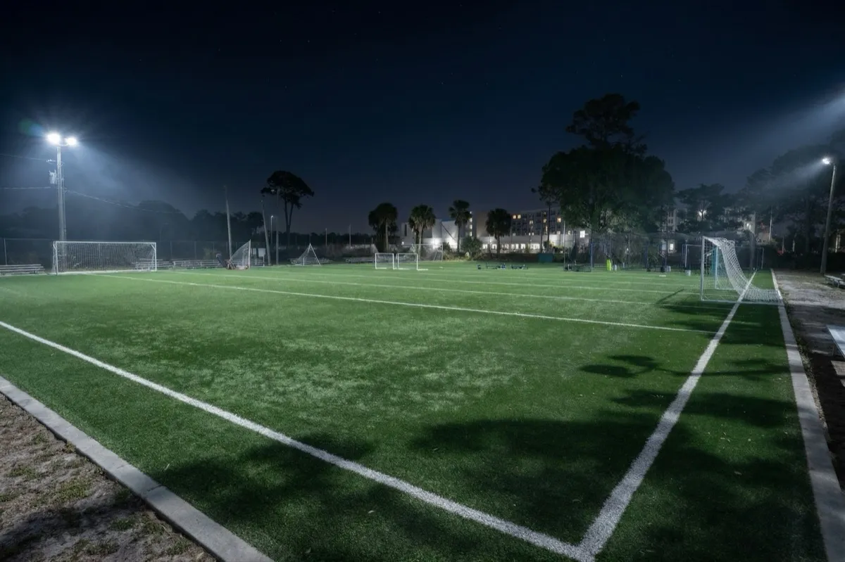 Floodlit artificial turf soccer field at night