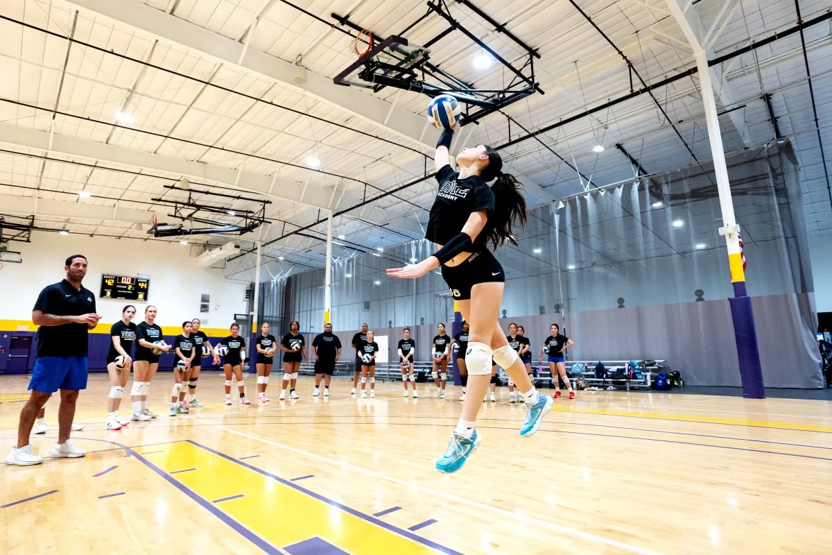 Indoor volleyball spike with coach watching during DME Academy training